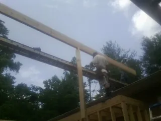 Carpenter setting a ridge beam over a new addition frame — Ice Dam Removal by Roofing Brothers in Bonanza